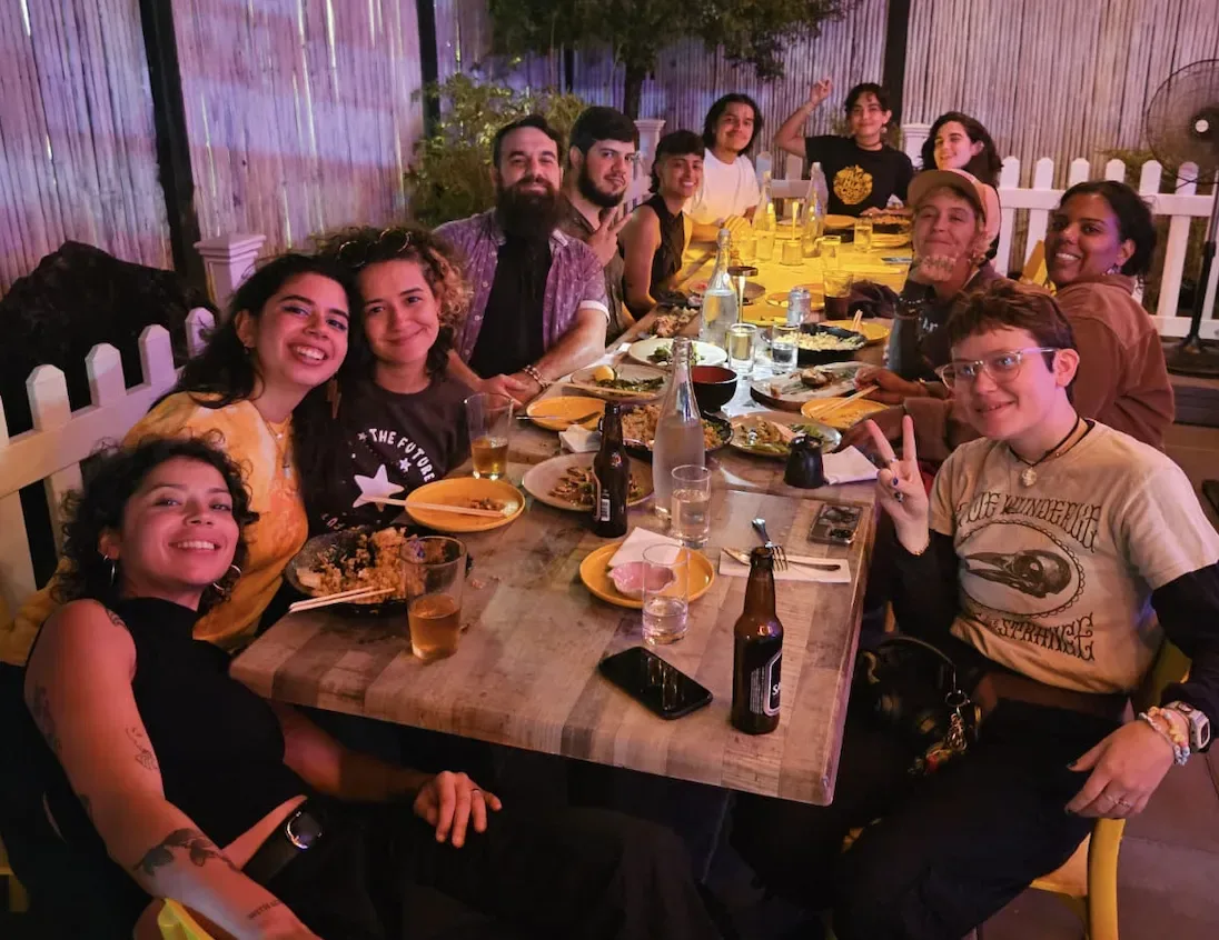 A long communal dinner table filled with Pana Mia members